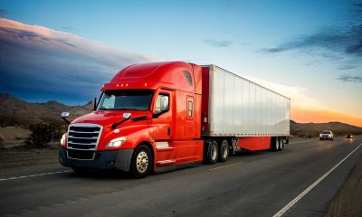 Business owner reviewing commercial truck financing options next to a semi truck