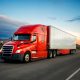 Business owner reviewing commercial truck financing options next to a semi truck